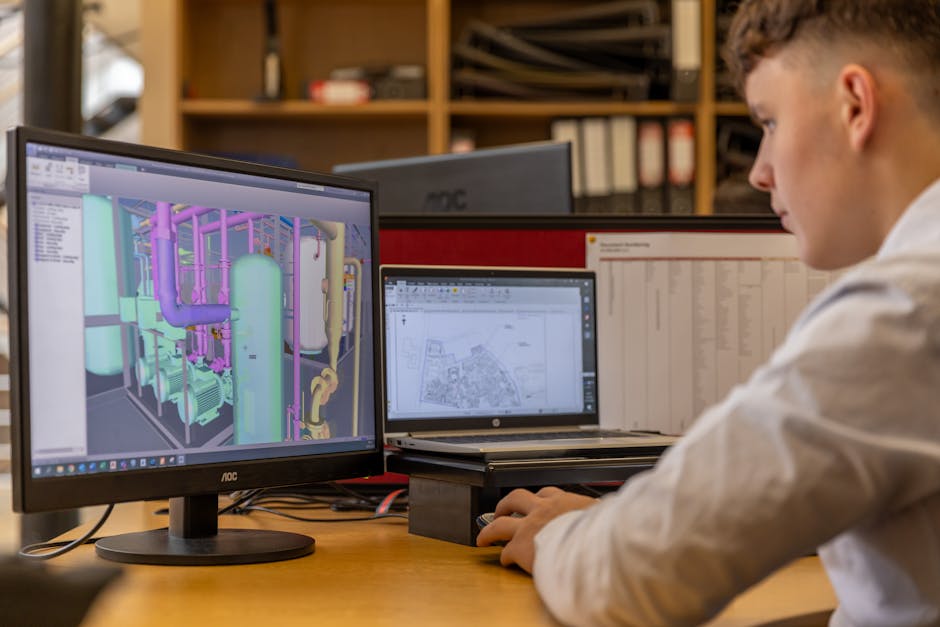 A man is looking at a computer screen with a computer