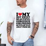 Man wearing a white t-shirt with playful text about his girlfriend's qualities.